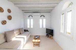 a white living room with a couch and a tv at Giagermos House in Dhió Kkhoriá
