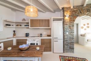 a kitchen with a table and a white refrigerator at Giagermos House in Dhió Kkhoriá