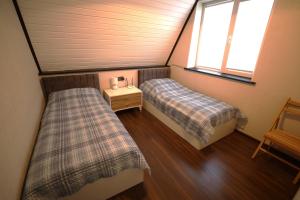 two beds in a small room with two windows at Mirvari Aframe in Quba