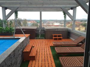 eine Dachterrasse mit einem Pool, Stühlen und einem Tisch in der Unterkunft Apartment Pulse Fitness in Benešov