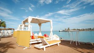 Labranda Royal Makadi في الغردقة: مجموعة من الكراسي و قارب على الشاطئ