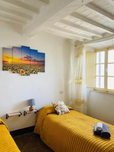 - une chambre avec un lit et une peinture murale dans l'établissement Il Campanile, à Montemerano