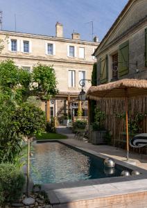 a swimming pool in front of a building at La Maison Mulatô, demeure privée d'hôtes, piscine & spa Libourne, Saint-Emilion in Libourne