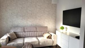 a living room with a couch and a flat screen tv at APARTAMENT JARACZA 28/17 in Słupsk