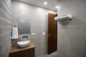 a bathroom with a sink and a mirror at The Indian Hotel Near Medanta Hospital in Gurgaon
