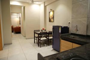 a kitchen and dining room with a table and chairs at 'Sumadhu Homes 301 ' in Kolhapur