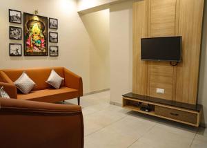 a living room with a couch and a flat screen tv at 'Sumadhu Homes 301 ' in Kolhapur