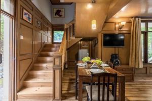 a tiny house with a dining room and stairs at Bear Creek: Luxury 2BHK Cottage near Mall Road in Manāli