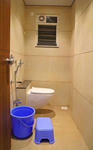 a bathroom with a toilet and a blue scale at 'Sumadhu Homes 301 ' in Kolhapur +7 photos
