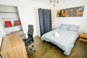 um quarto com uma cama, uma secretária e uma cadeira em T4 Spacieux , Découvrez le calme du Petit Charran em Valence