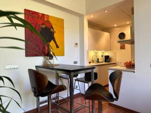 uma cozinha com uma mesa preta e cadeiras num quarto em Cozy Place Picasso em Barcelona