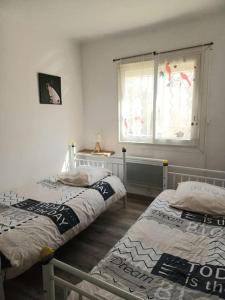 2 Einzelbetten in einem Zimmer mit Fenster in der Unterkunft appartement 2 chambre, plage à 50m in Palavas-les-Flots
