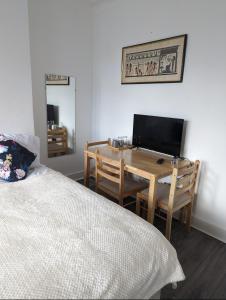 a bedroom with a bed and a desk with a computer at Tottenham Stadium Rooms 1 in London