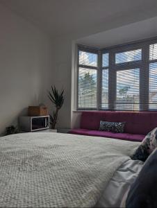 a bedroom with a large bed with a purple couch at Tottenham Stadium Rooms 1 in London