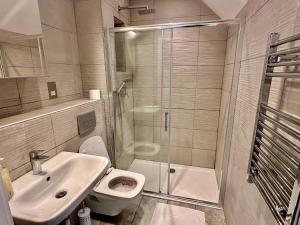 ein Bad mit einem WC, einem Waschbecken und einer Dusche in der Unterkunft Upminster Bridge Station Excel House in Hornchurch