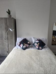 a bedroom with a bed with two pillows on it at Tottenham Stadium Rooms 1 in London
