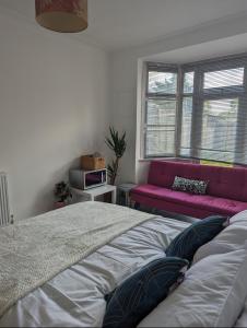 a bedroom with a bed and a pink couch at Tottenham Stadium Rooms 1 in London