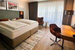 a bedroom with a bed and a table and chairs at Aspire Palais Recklinghausen, Trademark Collection by Wyndham in Recklinghausen