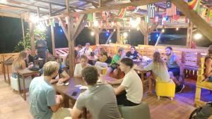 um grupo de pessoas sentadas em mesas em um restaurante em Angin Mamiri Rinjani Cottages And Restaurant em Senaru