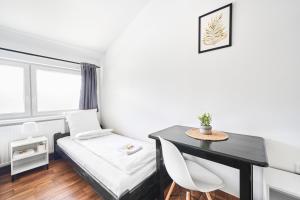 a small room with a bed and a desk at Hostel L44 in Nowy Targ