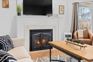 a living room with a fireplace and a table at The Birch House in Coeur d'Alene