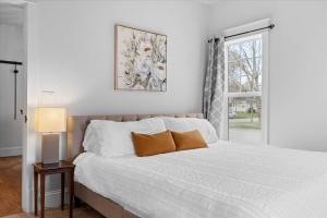a bedroom with a bed with white sheets and a window at The Birch House in Coeur d'Alene