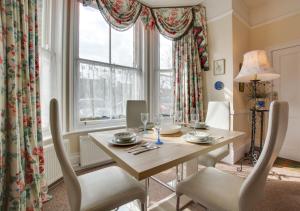 a dining room with a table and chairs and a window at South Flat in Wells next the Sea