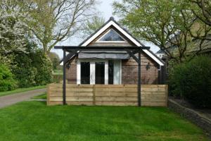 een klein huis met een houten hek in het gras bij Vakantiewoning 't Stookhok Gasselte in Gasselte +37 foto's