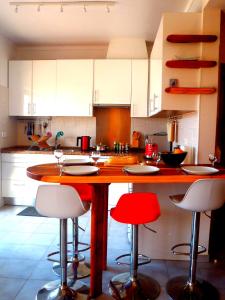 a kitchen with a wooden island with four bar stools at Vista Real in Vila Nova De Cacela
