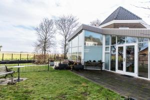 a glass extension of a house with a garden at Studio Kapitein in Ballum