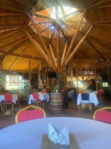una sala da pranzo con tavoli, sedie e botte di Brisaas de Agua Buena a San Fernando