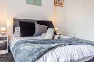 a person laying on a bed with a blanket at Guest Homes - Bambro Flat in Sunderland