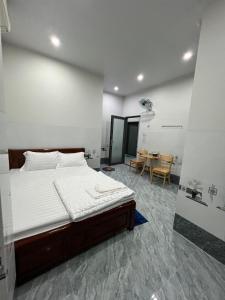 - une chambre avec un grand lit et une table dans l'établissement Nhà nghỉ Sunmi, à Cần Thơ