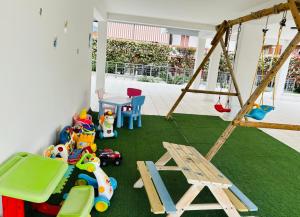 uma área recreativa com brinquedos e um baloiço em Acca residence em Terracina