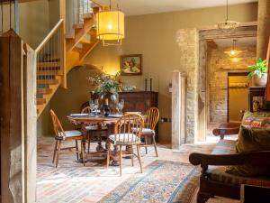 uma sala de jantar com mesa e cadeiras em The Stables at Stoneythorpe em Southam