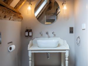 The Stables at Stoneythorpe في ساوثهام: حمام مع حوض أبيض ومرآة