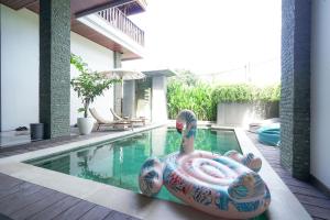 Tropical Beach House Bali في سمينياك: حمام سباحة مع التمساح الملون في الوسط