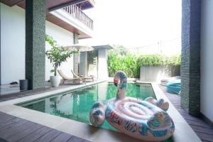 una piscina con un colorido inflador en el medio en Tropical Beach House Bali, en Seminyak
