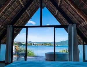 a room with a large window with a view of the water at Hotel Bambu in Santiago Atitlán