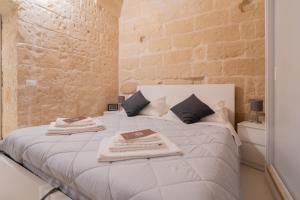 um quarto com uma cama branca e toalhas em DIMORA BAROCCA Apartment Irene em Lecce