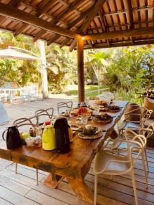 a wooden table with food on it on a patio at Pousada Big Bambu in Trancoso