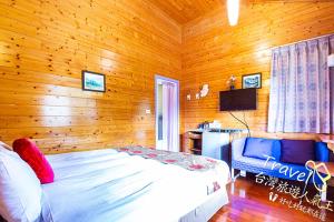 魚池鄉的住宿－快樂腳歐風鄉村民宿，木制客房内的一间卧室,配有一张床