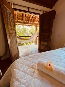 a bedroom with a bed with a flower on it at Pousada Big Bambu in Trancoso