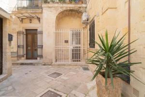 un edificio con una puerta y una planta en un patio en DIMORA BAROCCA Apartment Irene en Lecce