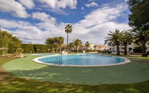 a swimming pool in a yard with palm trees at Tres Playas Primera línea de mar - ALBERT VILLAS Alcossebre in Alcossebre