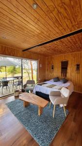 a bedroom with a bed and a wooden ceiling at Cabaña en el bosque Chiloé in Curaco de Velez