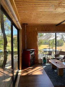 a screened in porch with a stove and a table at Cabaña en el bosque Chiloé in Curaco de Velez