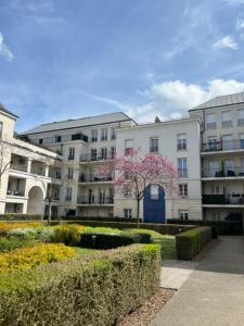 a white building with a pink tree in front of it at Appartement 7 personnes - Disneyland Paris in Serris