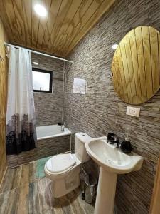 a bathroom with a toilet and a sink at Cabaña en el bosque Chiloé in Curaco de Velez
