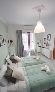 1 dormitorio con 1 cama verde grande con almohadas blancas en Studio Despoina, en Skala Kallonis